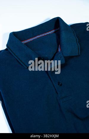 Polo blu piegata su sfondo bianco, ideale per la pubblicità di abbigliamento Foto Stock