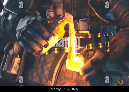 Un uomo con una tuta protettiva dà fuoco a un cocktail Molotov. Foto Stock