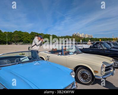 Monaco, Germania. 27 aprile 2025. Un fotografo scatta foto di convertibili classiche durante l'incontro con auto d'epoca organizzato dall'Automobil Club Munchen (ACM) a Theresienwiese a Monaco di Baviera, Baviera, alta Baviera, Germania, il 27 aprile, 2025. la mostra all'aperto presenta un'ampia varietà di veicoli storici che attirano appassionati di auto e fotografi. (Foto di Michael Nguyen/NurPhoto) credito: NurPhoto SRL/Alamy Live News Foto Stock