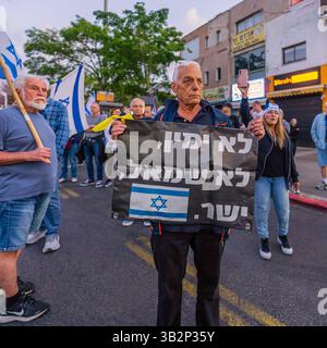 Haifa, Israele - 26 aprile 2025: Persone con vari segni e bandiere prendono parte a una manifestazione di protesta che chiede la fine della guerra, il completamento dell'ostaggio de Foto Stock