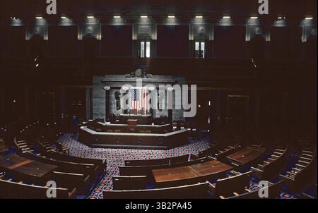 1 gennaio 1989 - Washington, District of Columbia, U. S - la camera della camera, nota anche come "sala della camera dei rappresentanti", è una grande sala riunioni situata al centro dell'ala sud del Campidoglio degli Stati Uniti. I membri della camera dei rappresentanti siedono in poltrone non assegnate disposte in un semicerchio su piattaforme a livelli che si affacciano sul rostro dello speaker. Dietro il rostro c'è un frontespizio con colonne ioniche realizzate in marmo nero italiano con capitelli bianchi in marmo dell'Alabama. Una bandiera americana occupa il centro ed è fiancheggiata da due facce di bronzo. Le pareti inferiori della camera sono rivestite in noce Foto Stock