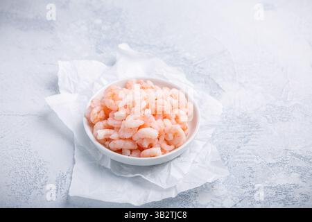 Ciotola con piccoli gamberetti pelati bolliti sul tavolo della cucina Foto Stock