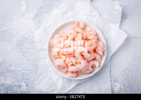 Ciotola con piccoli gamberetti pelati bolliti sul tavolo della cucina Foto Stock