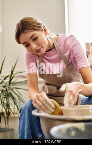 Un artigiano dedicato trasforma l'argilla in un bellissimo pezzo di ceramica, circondato da ispirazione artistica. Foto Stock