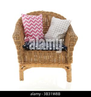 Sedia in vimini con cuscini colorati Foto Stock