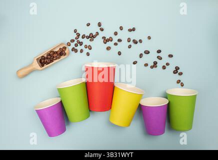 Vista dall'alto in stile business delle tazze da caffè colorate su sfondo blu, concepita per la grafica e il branding dei prodotti Foto Stock