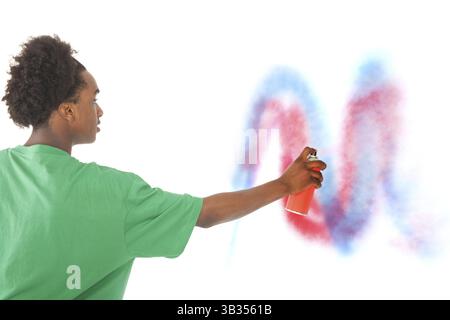 Giovane nero Graffiti artist è spruzzando a parete Foto Stock