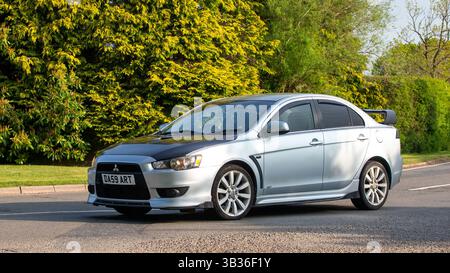 Whittlebury, Northants.,.UK - 27 aprile 2025: 2009 auto Mitsubishi Lancer che guida su una strada di campagna inglese. Foto Stock