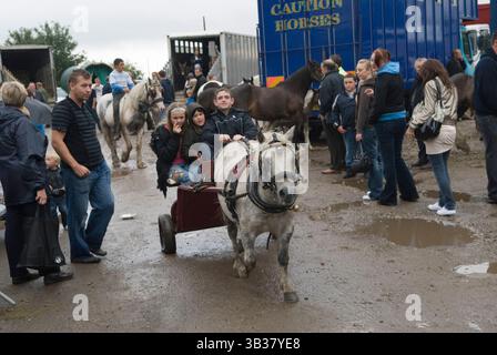 I bambini in pony e trappola si divertono tra i viaggiatori zingari e i mercanti di cavalli. Brigg, Lincolnshire, Inghilterra 5 agosto 2009 2000s UK HOMER SYKES Foto Stock