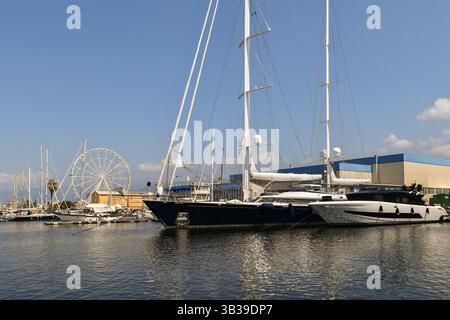 Mega yacht attraccati davanti a rinomati cantieri navali nel porto, con la ruota panoramica sullo sfondo, Viareggio (Lucca), Toscana, Italia Foto Stock