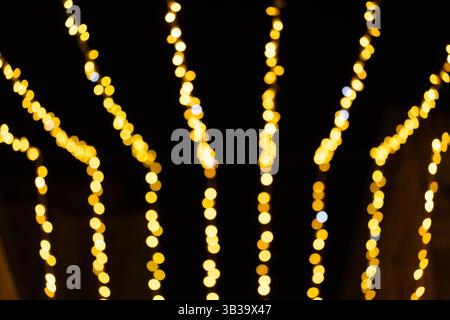 Luci a corde dorate sfocate nel cielo notturno Foto Stock