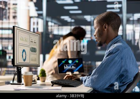 Imprenditore maschile che conduce la pianificazione finanziaria e la definizione degli obiettivi, dimostrando esperienza nella gestione del bilancio. CEO che analizza i report e le previsioni online per promuovere i piani di crescita dell'azienda. Foto Stock