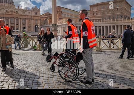 Città del Vaticano, Vaticano - 25 aprile 2025: Due membri del personale Vaticano che assistono i disabili in Piazza San Pietro. Foto Stock