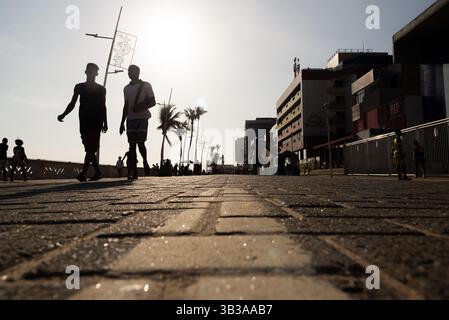 Salvador, Bahia, Brasile - 5 gennaio 2025: I turisti sono visti camminare sul lungomare di Farol da barra durante il tramonto. Salvador, Bahia. Foto Stock
