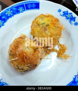 Perkedel kentang o tradizionali polpette di patate speziate indonesiane in un ristorante Masakan Padang servito su un piatto come contorno Foto Stock