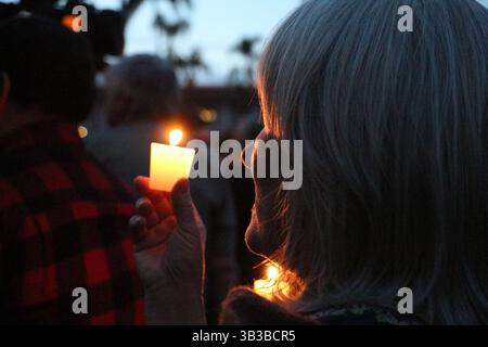 14 gennaio 2018 - Santa Barbara, California, Stati Uniti - Una donna tiene una candela durante la veglia a lume di candela per le vittime della frana di Montecito, alla quale hanno partecipato migliaia di membri della comunità presso i Santa Barbara Sunken Gardens. I politici locali e statali, i leader del Clery e della comunità hanno tenuto discorsi sinceri mentre i residenti accedevano le candele, cantavano e piangevano per i loro vicini e per il paesaggio devastato. (Immagine di credito: © Amy Beth Katz via ZUMA Wire) Foto Stock