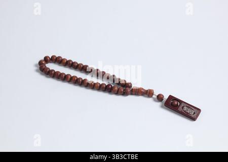 Primo piano di perle di preghiera di legno, uno strumento per il dhikr musulmano, isolato su sfondo bianco Foto Stock