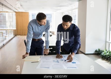 Due professionisti del settore impegnati nell'analisi dei documenti finanziari Foto Stock