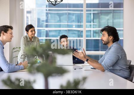 Il team leader di mezza età fa un discorso durante il briefing in sala conferenze Foto Stock