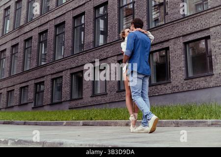 un partner innamorato incontra una ballerina in una strada della città mentre cammina per la città in un giorno d'estate Foto Stock