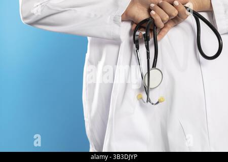 Vista posteriore con le mani di una giovane dottoressa che tiene in mano uno stetoscopio Foto Stock