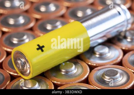 Più utilizzate batterie alcaline AA e una singola batteria AAA sono visti disposti in una pila. Primo piano vista laterale dal lato più della batteria. Singola Foto Stock
