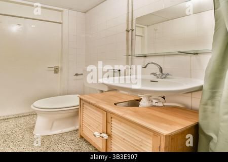 Questa immagine presenta un bagno moderno dal design elegante, con linee pulite e arredi minimali, che enfatizzano la funzionalità e l'efficienza dello spazio. Foto Stock