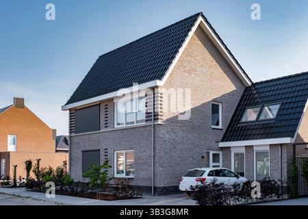 Accoccolata in un tranquillo sobborgo dei Paesi Bassi, questa collezione di moderne case familiari presenta design eleganti e layout spaziosi, ideali per la vita in famiglia. Un mix perfetto di comfort e stile. Foto Stock