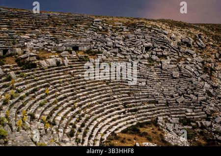 I livelli di sedili in pietra crollati cadono giù ripidamente in pendenza della cavea del teatro romano del II secolo d.C. nei resti dell'antica città pisidiana di Sagalassos ad Aglasun, provincia di Burdur, Turchia sud-occidentale. Nonostante molti danni sismici, molti monumenti di questa metropoli provinciale scavata sono sopravvissuti. Foto Stock