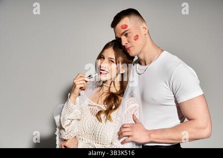 Gli sposi e gli sposi allegri condividono un momento dolce con giocosi rossetti di romanticismo. Foto Stock