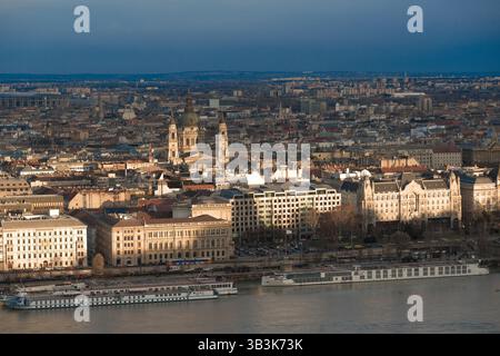Il sole sta tramontando su budapest, gettando lunghe ombre sul danubio e mettendo in risalto la splendida architettura della città Foto Stock