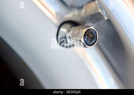 Dettaglio vettura immagine del dado del tappo esagonale del coperchio della valvola del nipplo pneumatico primo piano selettivo Foto Stock