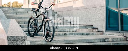 Giovane che va in bicicletta giù per le scale in ambiente urbano Foto Stock