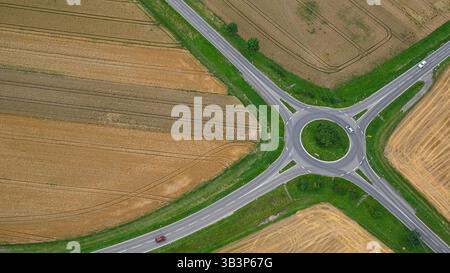 Strada di campagna, autostrada e cerchio di traffico dall'alto con vista droni o da un aereo con veicoli; auto sul paesaggio autostradale. Foto Stock