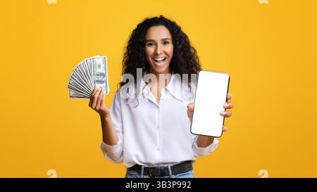 Concetto di cashback. Smartphone di Young Woman Holding e Dollar Cash eccitati Foto Stock