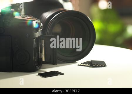 Schede di memoria SD e fotocamere su tavolo bianco, primo piano Foto Stock