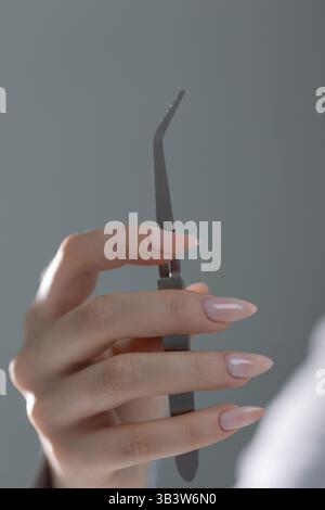 Gli strumenti di manicure sono a portata di mano per lavorare su una bella manicure beige, primo piano di un salone. Foto Stock