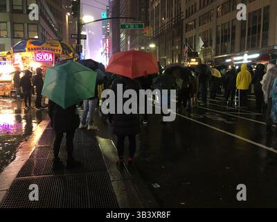 L'iconica Times Square a New York con enormi schermi pubblicitari, luci luminose e folle che camminano attraverso le strade trafficate della città Foto Stock