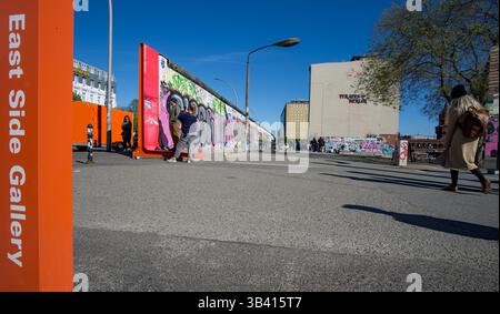 Visitatori della East Side Gallery, la famosa galleria d'arte all'aperto di Berlino sui resti del muro di Berlino Foto Stock