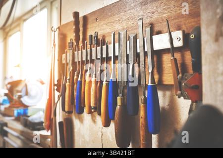 Svuotare l'officina con attrezzi e attrezzature fai da te. Set di cacciaviti e lime da carpentiere appese nel garage. Officina di riparazione e bulloneria per legno per Foto Stock