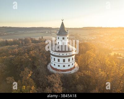 Mentre il sole sorge sul Paradiso boemo, lo splendido castello barocco di Humprecht si erge alto sopra Sobotka, circondato dai vibranti colori del fogliame autunnale e dalla tranquilla campagna. Foto Stock
