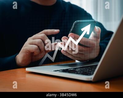 Tecnologia di investimento, finanziaria, ritorno sull'investimento - concetti ROI. La freccia digitale in aumento viene visualizzata mentre un uomo d'affari utilizza uno smartphone per ana Foto Stock