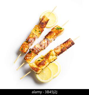 Spiedini satay di tofu grigliati con fette di limone isolate sul dorso bianco, vista dall'alto. Kebab al formaggio halloumi fritti. Cibo vegetariano vegetariano. Foto Stock