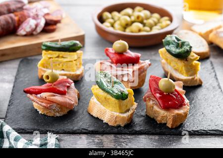 Pinchos spagnoli tradizionali su tavolo di legno Foto Stock