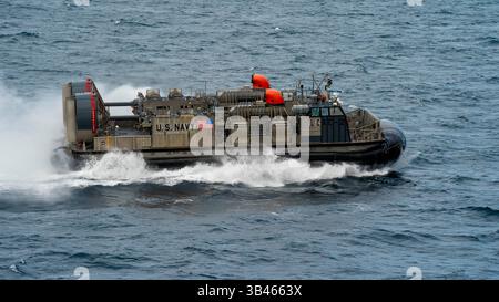 OCEANO ATLANTICO (27 aprile 2025) — Un Landing Craft, Air Cushion (LCAC) transita lungo la nave da sbarco anfibia classe Harpers Ferry USS Oak Foto Stock