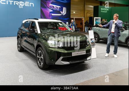 Riga, Lettonia - 25 aprile 2025: Un SUV Citroen e-C3 Aircross viene presentato ad un evento, con un oratore che ne spiega le specifiche. Foto Stock