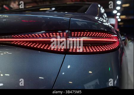 Vista ravvicinata della luce di posizione posteriore di un'auto di lusso che mette in evidenza elementi di design innovativi all'interno. Foto Stock