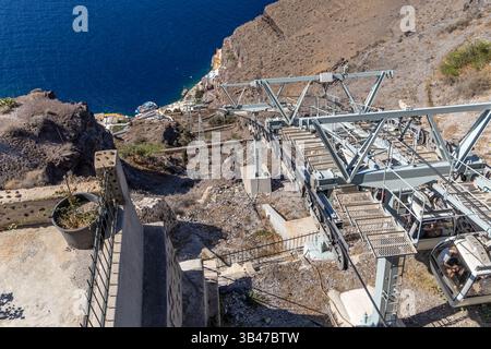 Santorini, Grecia - 15 ottobre 2024: Mechanical Marvel: Santorini Cable Cars Traverse the ripide Volcanic Cliffs. Foto Stock