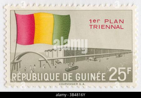 GUINEA - 1960 ottobre 2: Francobollo multicolore da 25 franchi raffigurante la bandiera del Paese, la sala espositiva e i veicoli a motore (automobili). Terzo anniversario dell'indipendenza, primo piano triennale. La Repubblica di Guinea è un paese costiero dell'Africa occidentale. Viene talvolta indicata come Guinea-Conakry dal nome della sua capitale Conakry, per distinguerla da altri territori della regione omonima come la Guinea-Bissau e la Guinea Equatoriale. Ex Guinea francese, ha raggiunto l'indipendenza nel 1958. Ha una storia di colpi di stato militari Foto Stock
