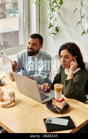 Una coppia afroamericana lavora insieme su progetti freelance in un caffè e dessert. Foto Stock